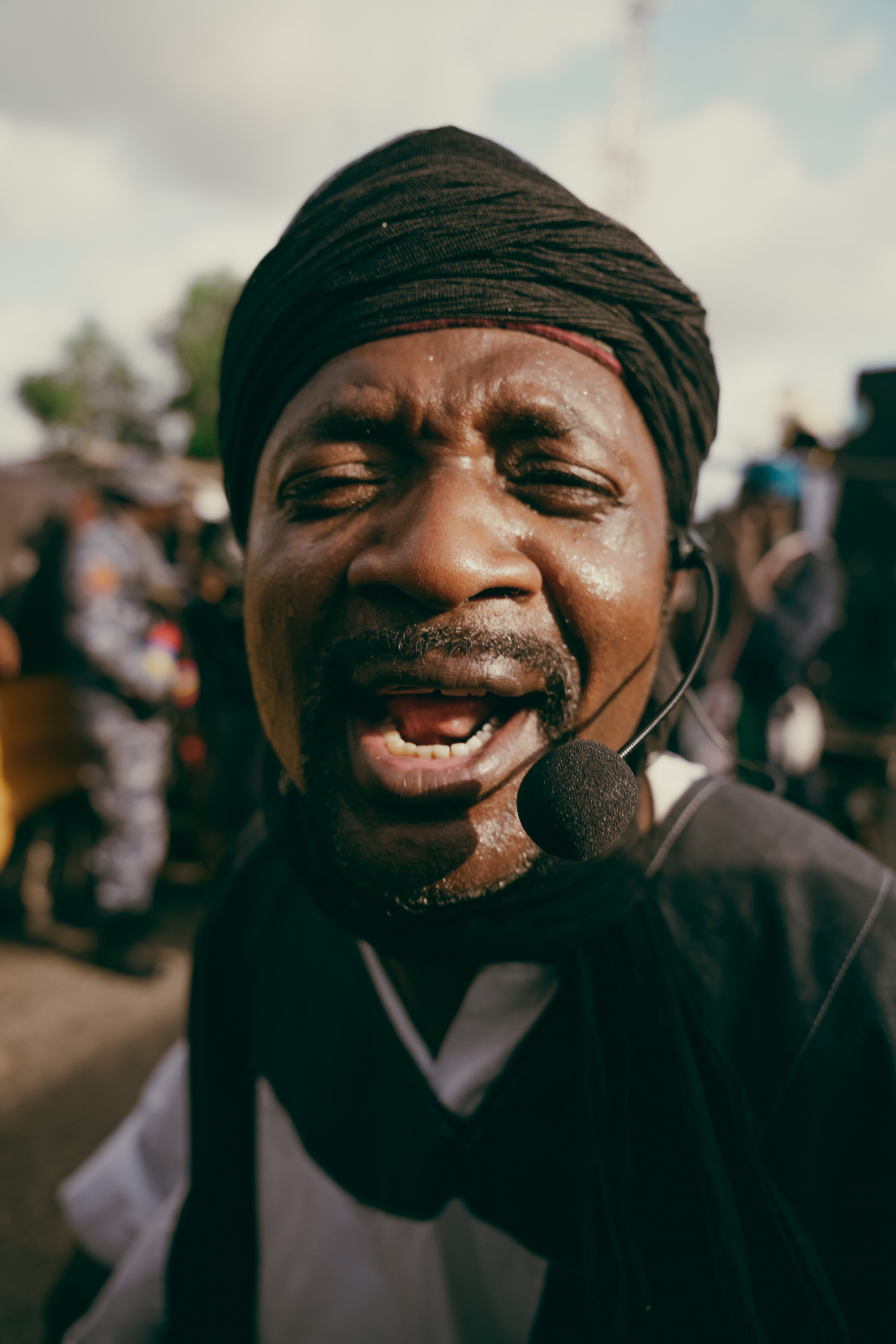 Close-up portrait of a performer singing into a headset microphone