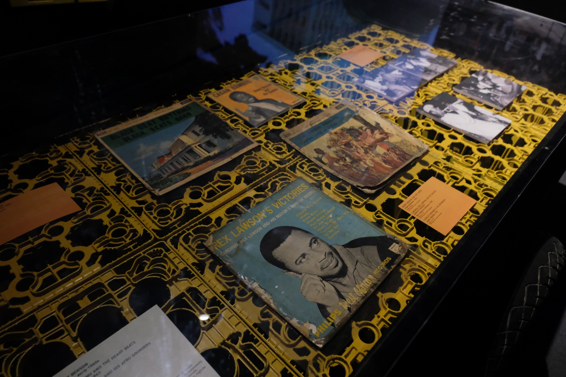 Vintage Nigerian highlife and Afrobeat vinyl records displayed in a yellow lattice vitrine at Afrobeat Rebellion